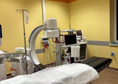 Sala zabiegowa z nowoczesnym stołem operacyjnym i urządzeniami diagnostycznymi