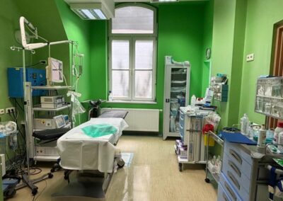 Medyczny gabinet z zielonymi ścianami i wyposażeniem do zabiegów